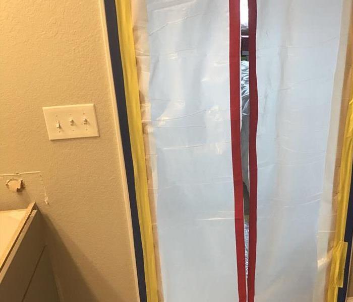 bathroom doorway with plastic sheeting over door
