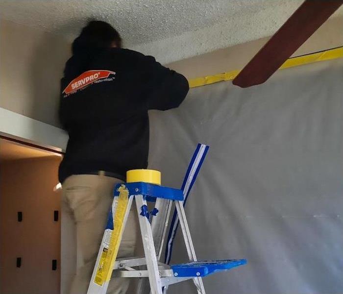 SERVPRO technician installing a plastic containment barrier