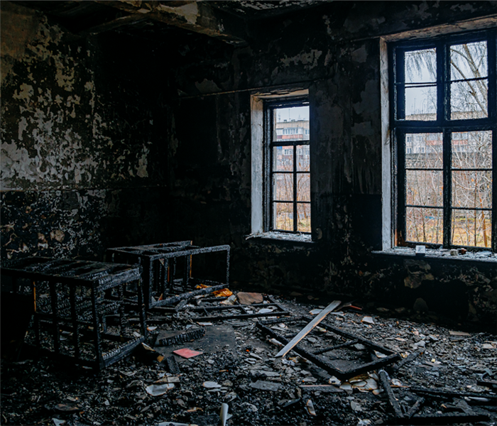 a fire damaged room with soot covering everything and debris everywhere
