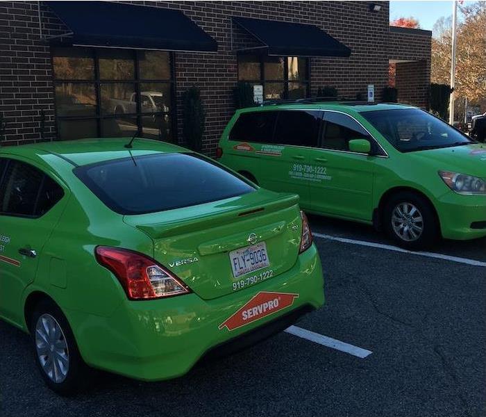 Two Green SERVPRO cars in a parking lot